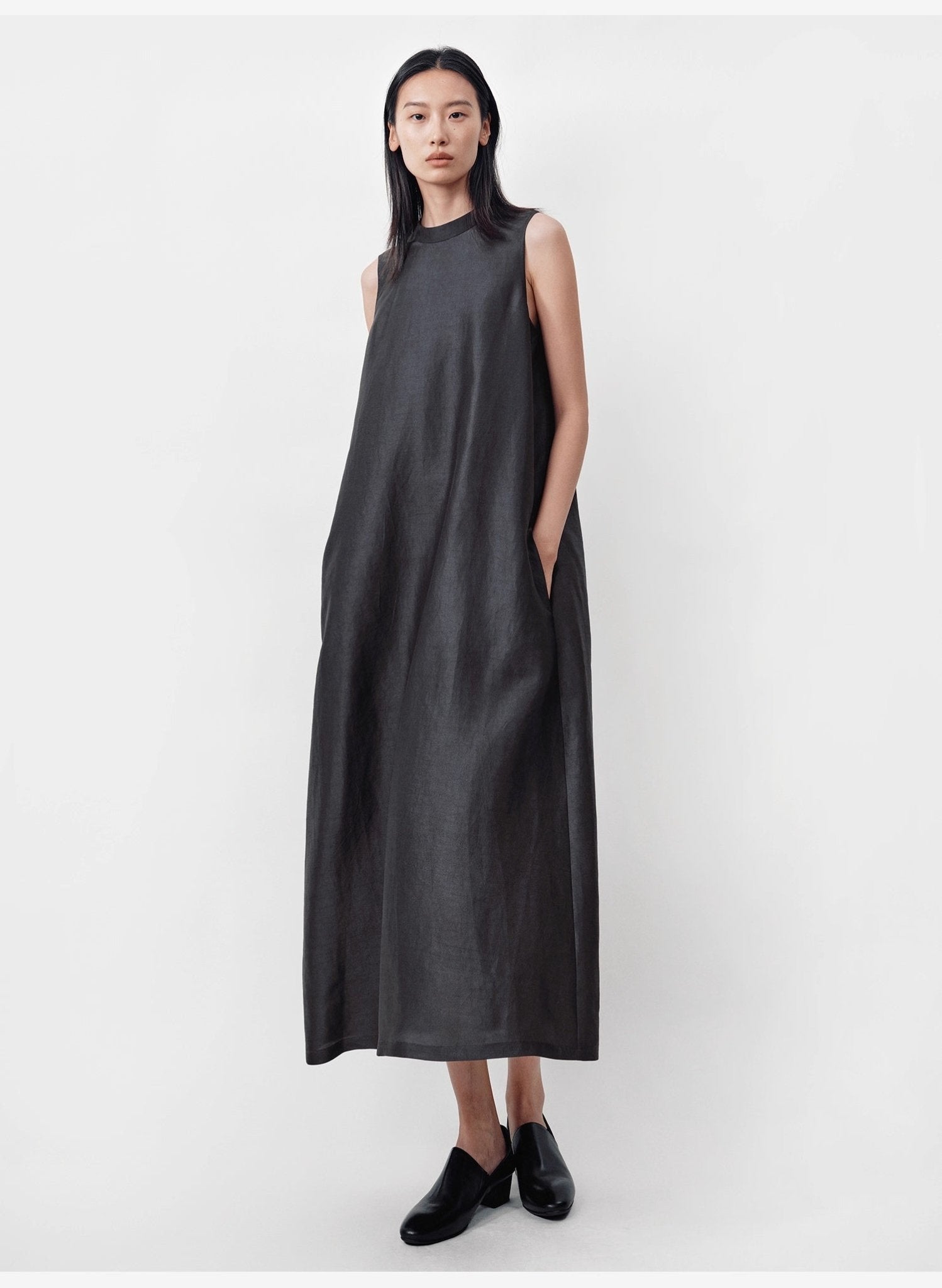 model standing up against grey wall wearing sleeveless Xiangyunsha silk dress