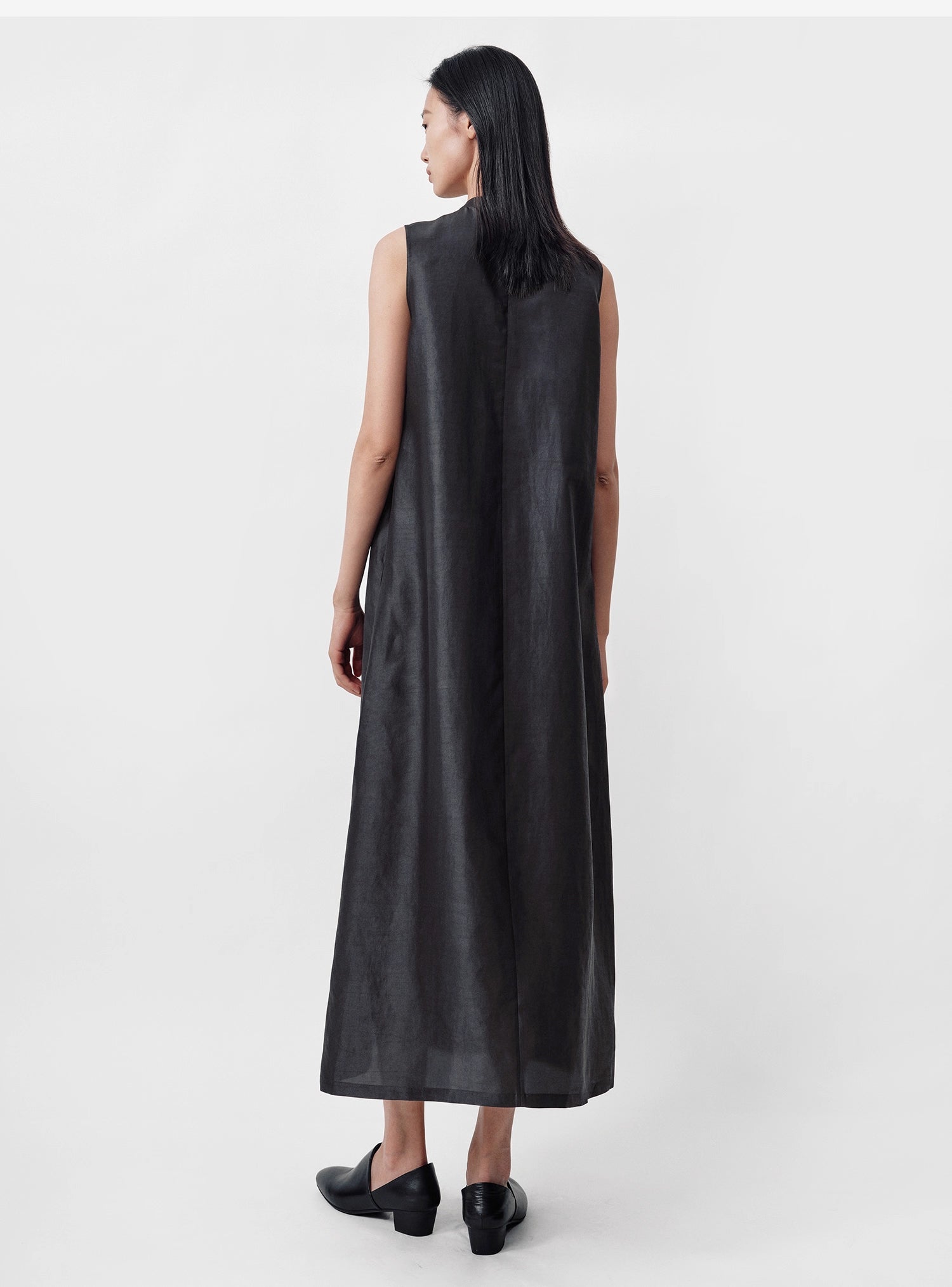 model standing facing the grey wall wearing sleeveless Xiangyunsha silk dress