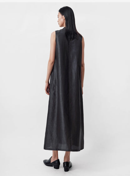 model standing facing the grey wall wearing sleeveless Xiangyunsha silk dress