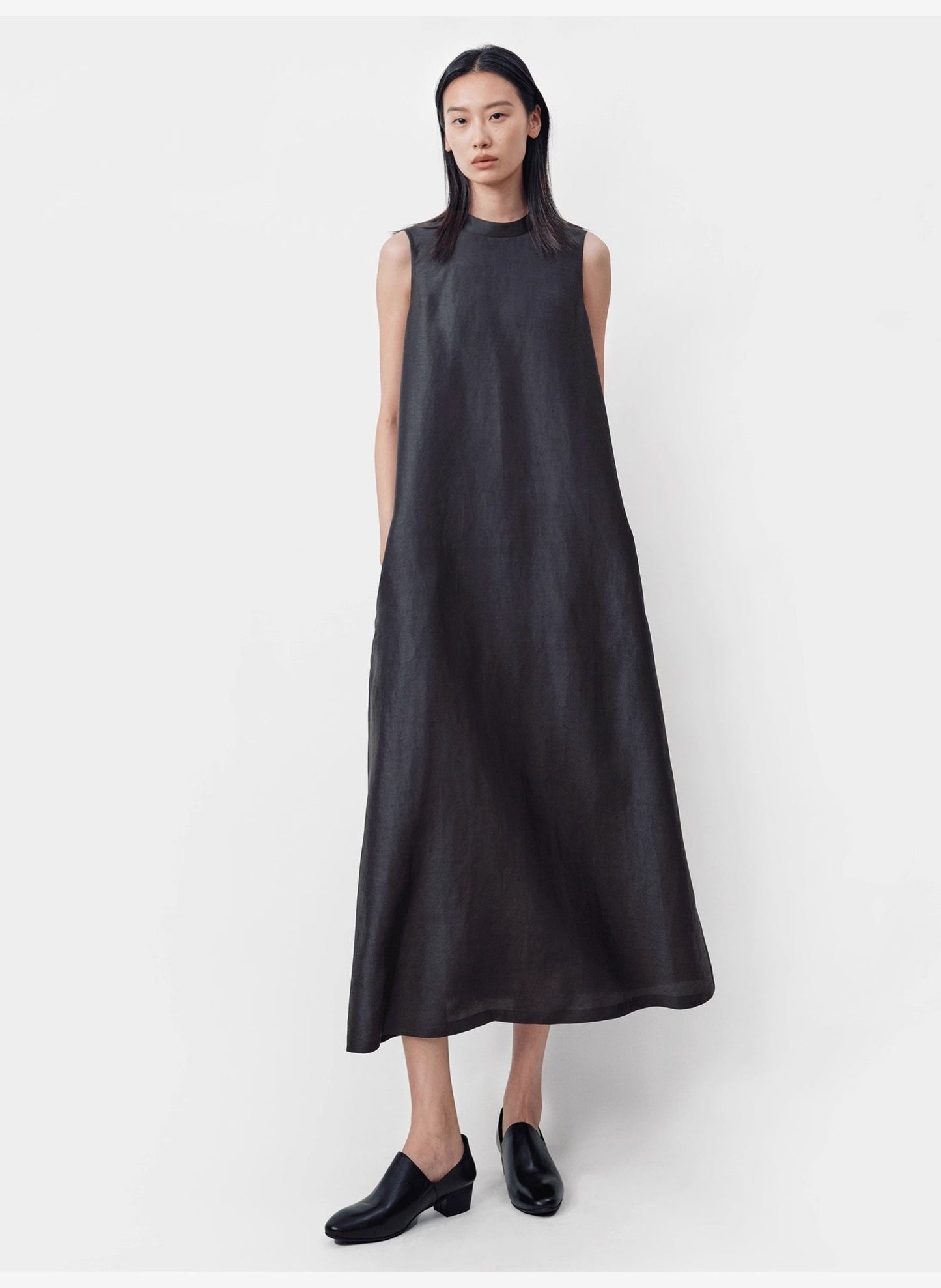 model standing up against grey wall wearing sleeveless Xiangyunsha silk dress